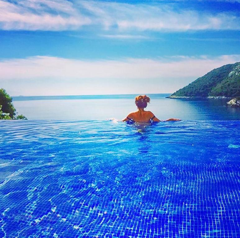 a woman in a swimming pool in the water at Villa Mirosa in Saplunara