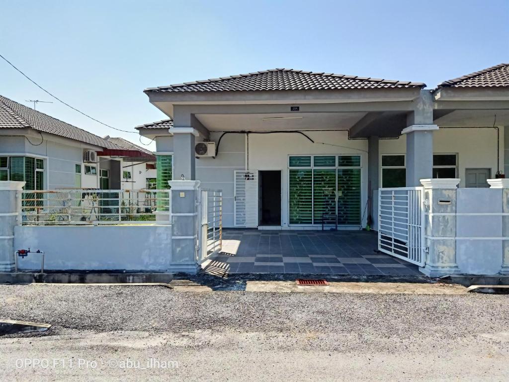una casa con una puerta delante de ella en Ilham Imani Homestay en Kampung Gurun