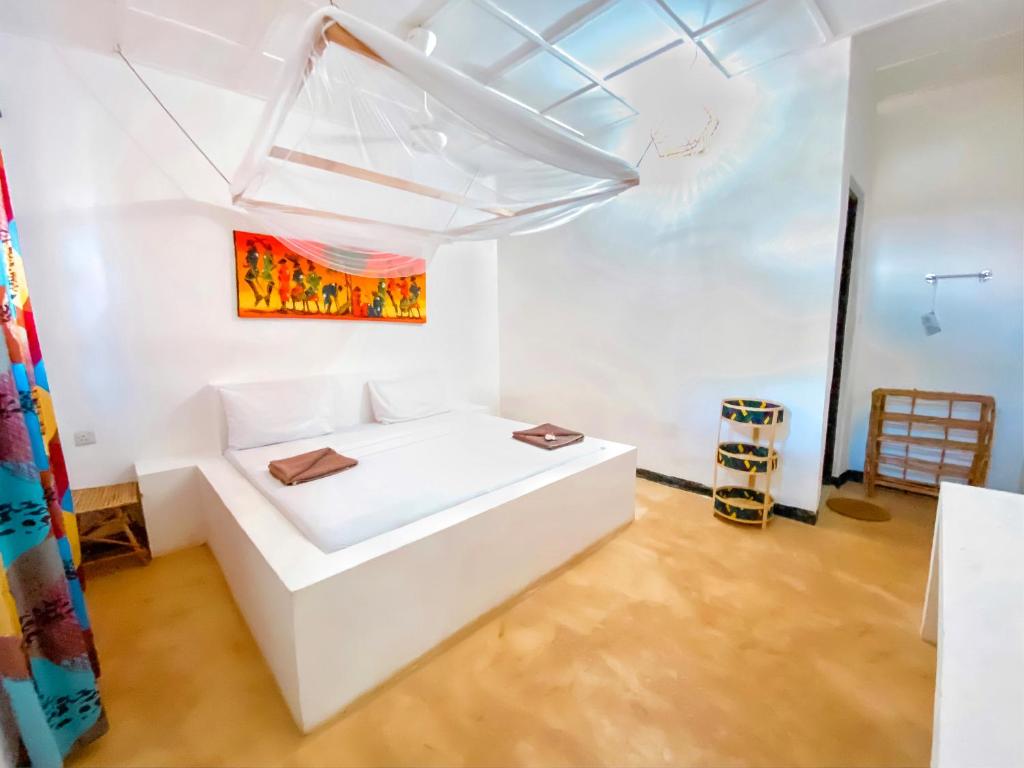 Postel nebo postele na pokoji v ubytování Papaya Guest House Nungwi