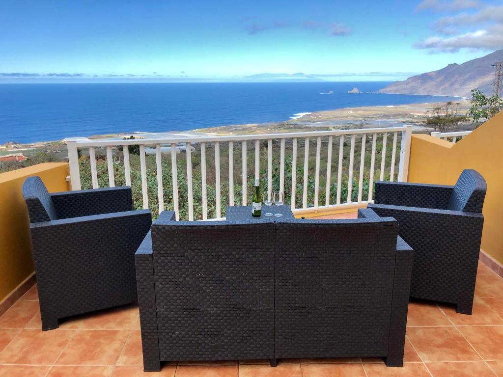 een balkon met een tafel en stoelen en de oceaan bij Vv Bimba in Frontera