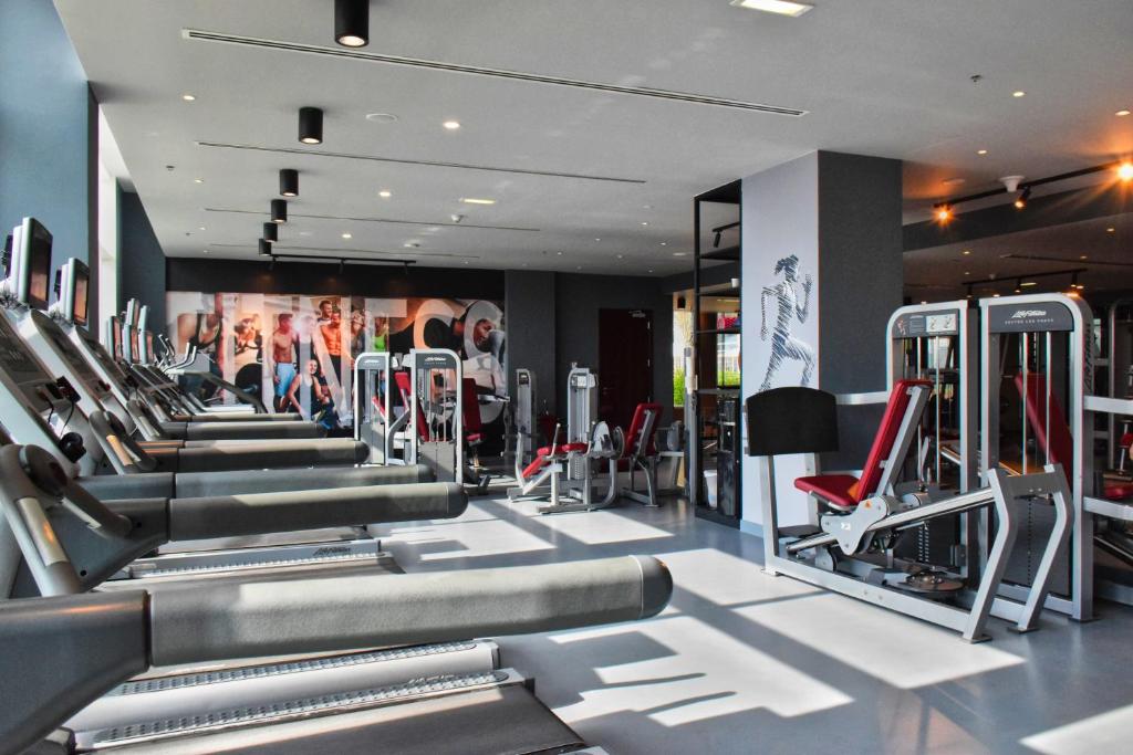 a gym with a row of tread machines at Centro Yas Island-by Rotana in Abu Dhabi