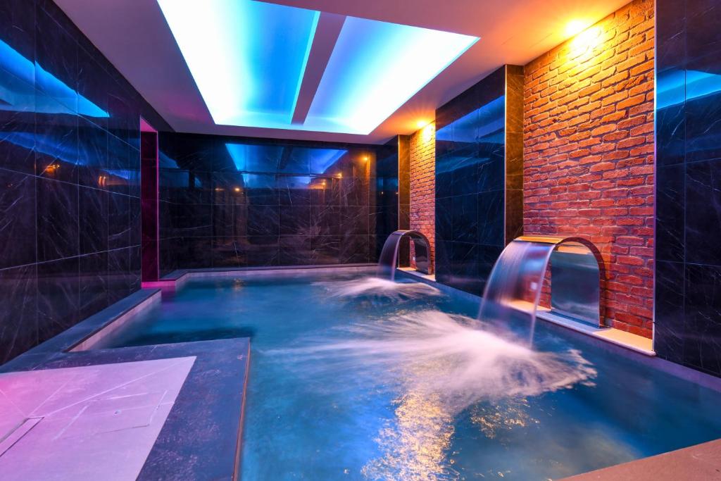 a jacuzzi tub with a waterfall in a room at Hotel Master in Brescia