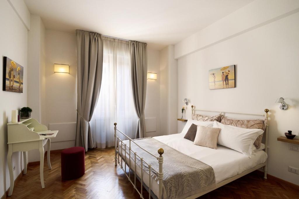 1 dormitorio con cama, escritorio y ventana en MyFlorenceHoliday Gold Bridge, en Florencia
