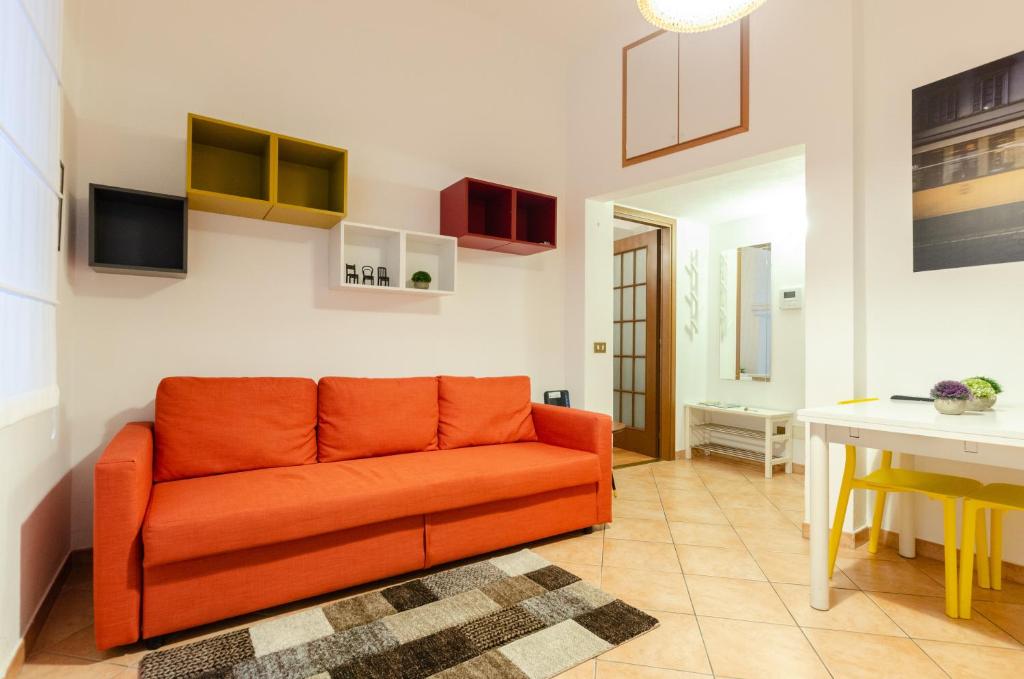 um sofá laranja numa sala de estar com uma mesa em Cozy Central Flat - Porta Romana - Duomo em Milão