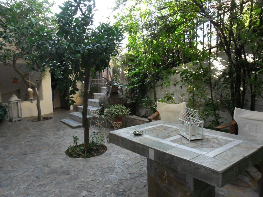 um pátio com uma mesa e árvores e uma estátua em Litsa em Plomari