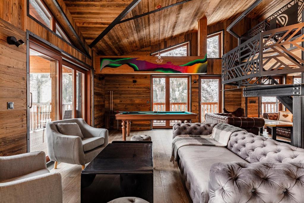 a living room with a couch and a pool table at Chalet Carte Blanche Raven in Tignes