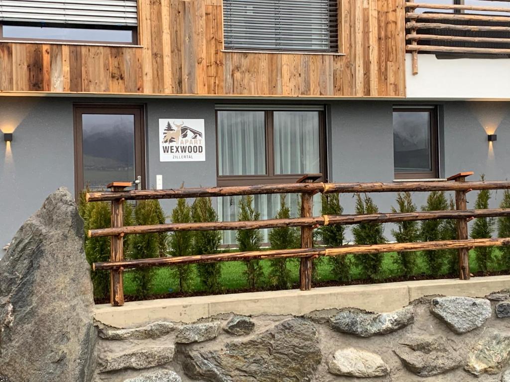 a wooden fence in front of a building at Apart Wexwood in Hart im Zillertal