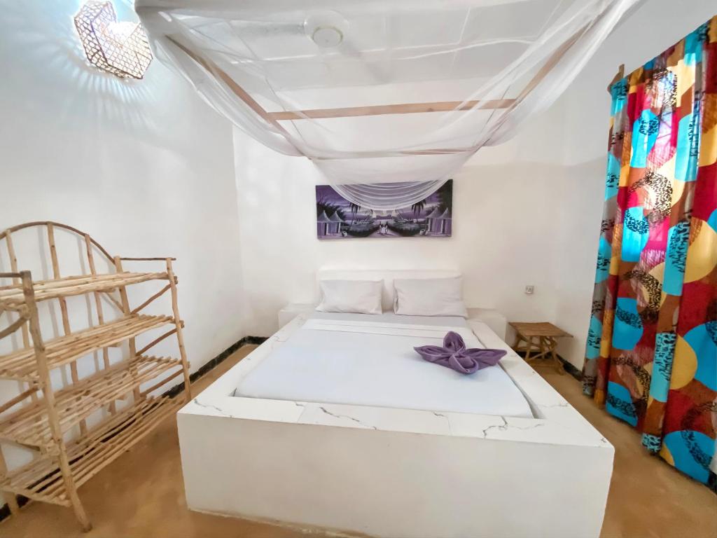 Postel nebo postele na pokoji v ubytování Papaya Guest House Nungwi