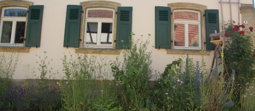 a garden in front of a house with green windows at Residenz Nr.6 in Zapfendorf