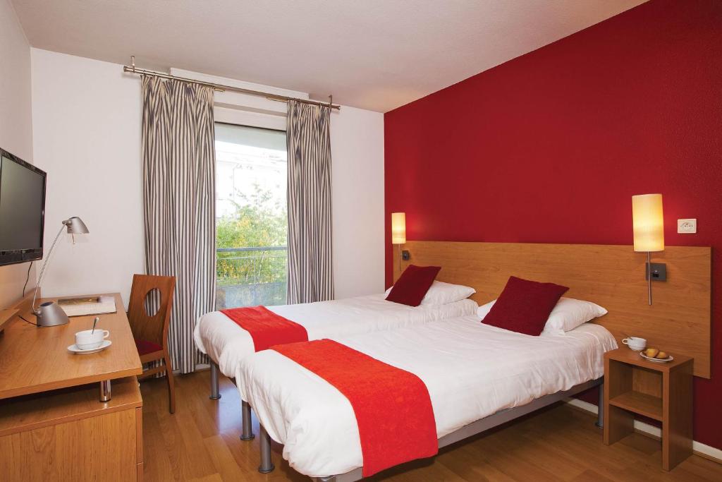 1 Schlafzimmer mit 2 Betten und einer roten Wand in der Unterkunft Séjours &amp; Affaires Lyon Saxe-Gambetta in Lyon