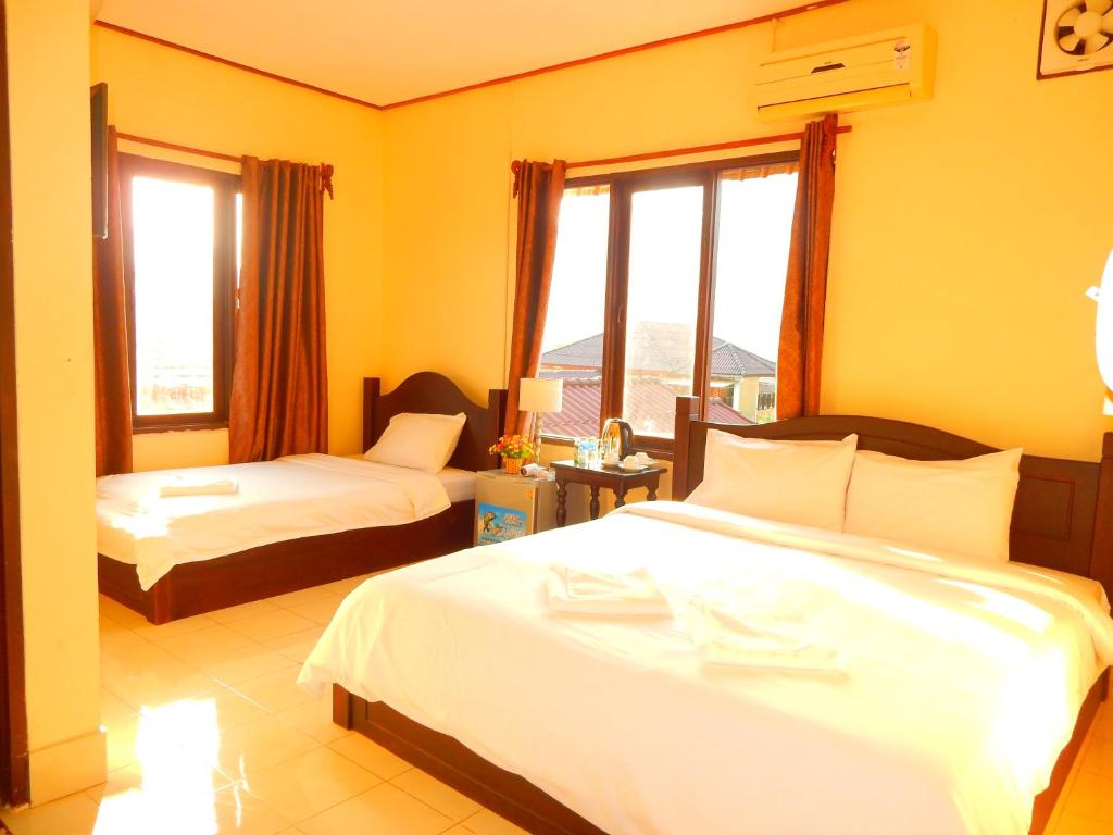 a hotel room with two beds and a window at Vang Vieng Camellia Hotel in Vang Vieng