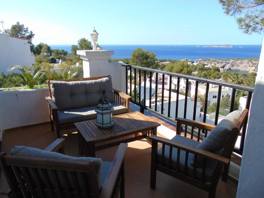 Un balcón con sillas y una mesa con vistas al océano. en Casa Sol & Mar, en Sant Josep de sa Talaia
