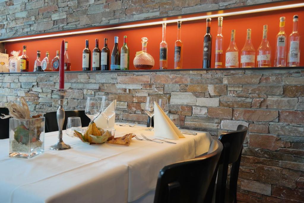einen Tisch in einem Restaurant mit Weinflaschen an der Wand in der Unterkunft Gasthaus zum Ochsen in Grosswangen