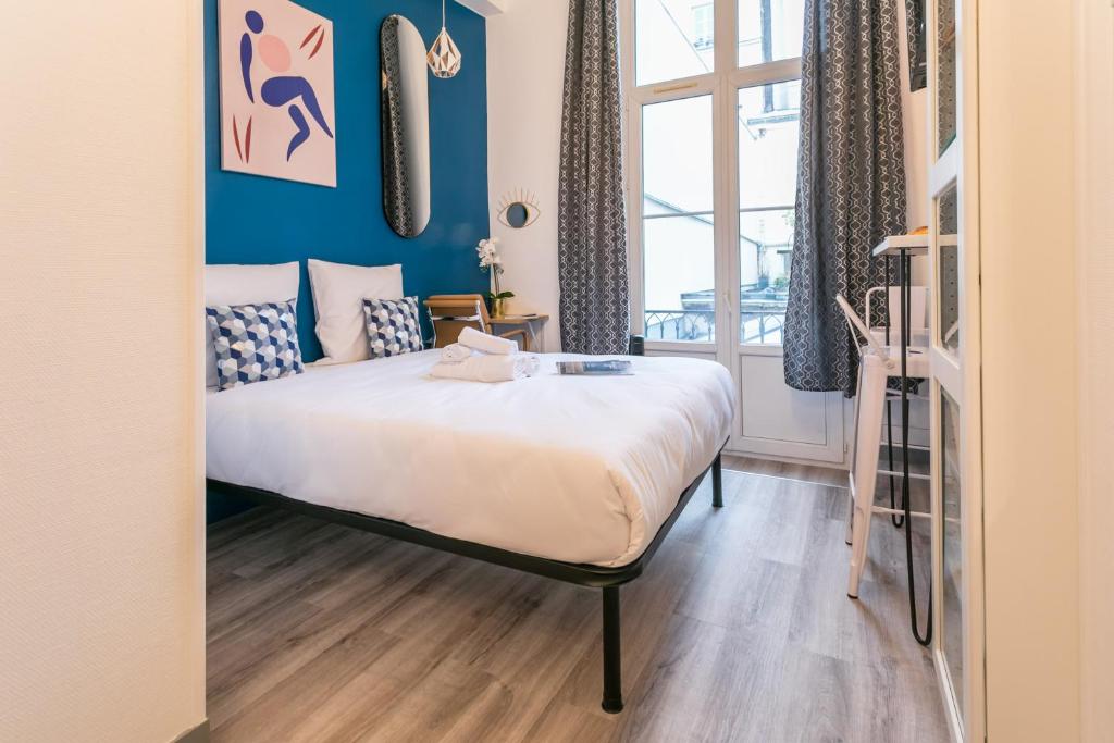 1 dormitorio con cama y ventana grande en Apartments WS Marais - République en París