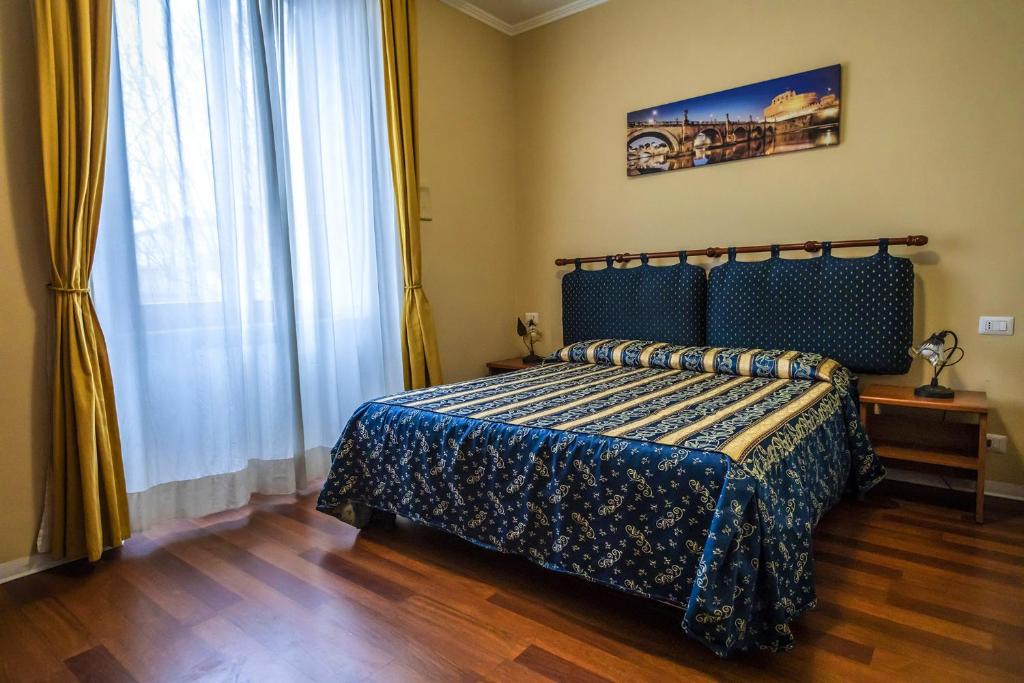 a bedroom with a bed with a blue comforter at Sole E Luna in Rome