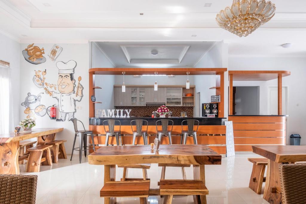 een eetkamer en een keuken met houten tafels en stoelen bij Urbanview Hotel One Family Maribaya by RedDoorz in Lembang