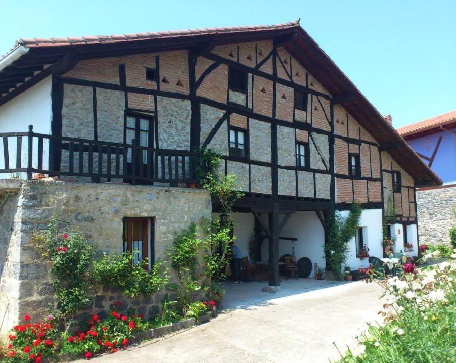 an old building with flowers in front of it at Casa Rural Ozollo in Gautegiz Arteaga