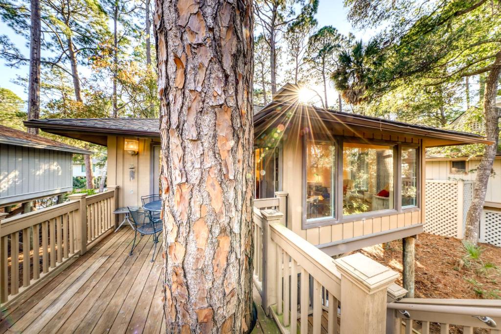 a house with a wooden deck next to a tree at 12 Inlet Cove Cottage in Kiawah Island