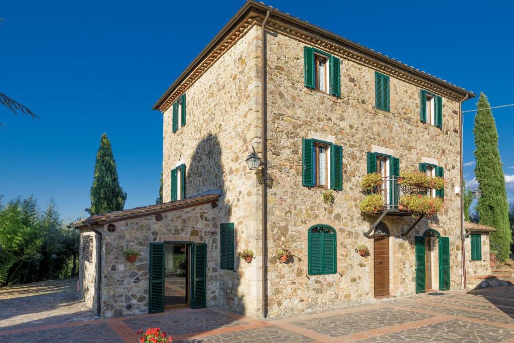 a large stone building with green shutters on it at Villa La Casa del Re in Le Piazze