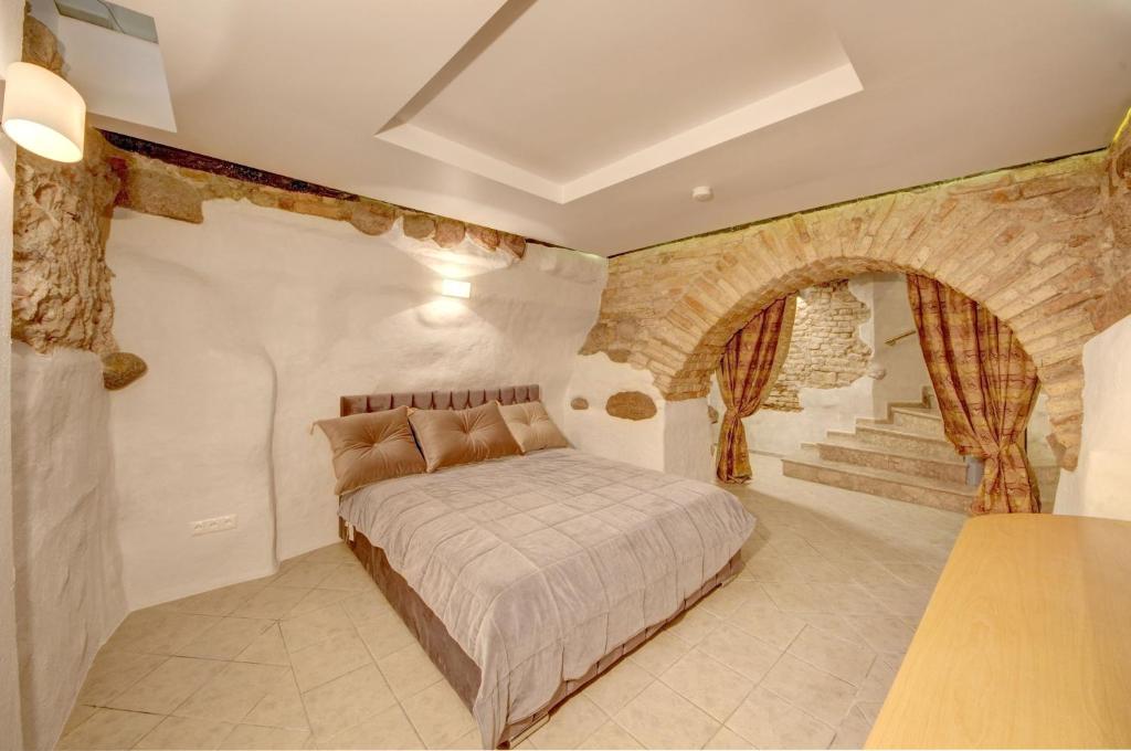 a bedroom with a bed and a stone wall at Vilnius Old town apartments in Vilnius