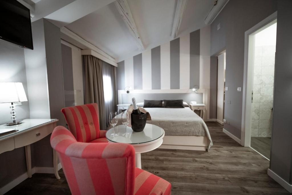 een hotelkamer met een bed en een tafel en stoelen bij Bonotto Hotel Belvedere in Bassano del Grappa