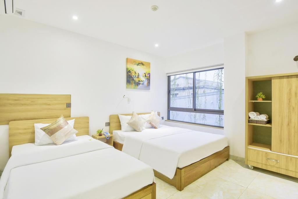 a bedroom with two beds and a window at Annie Danang Hotel & Apartment in Danang