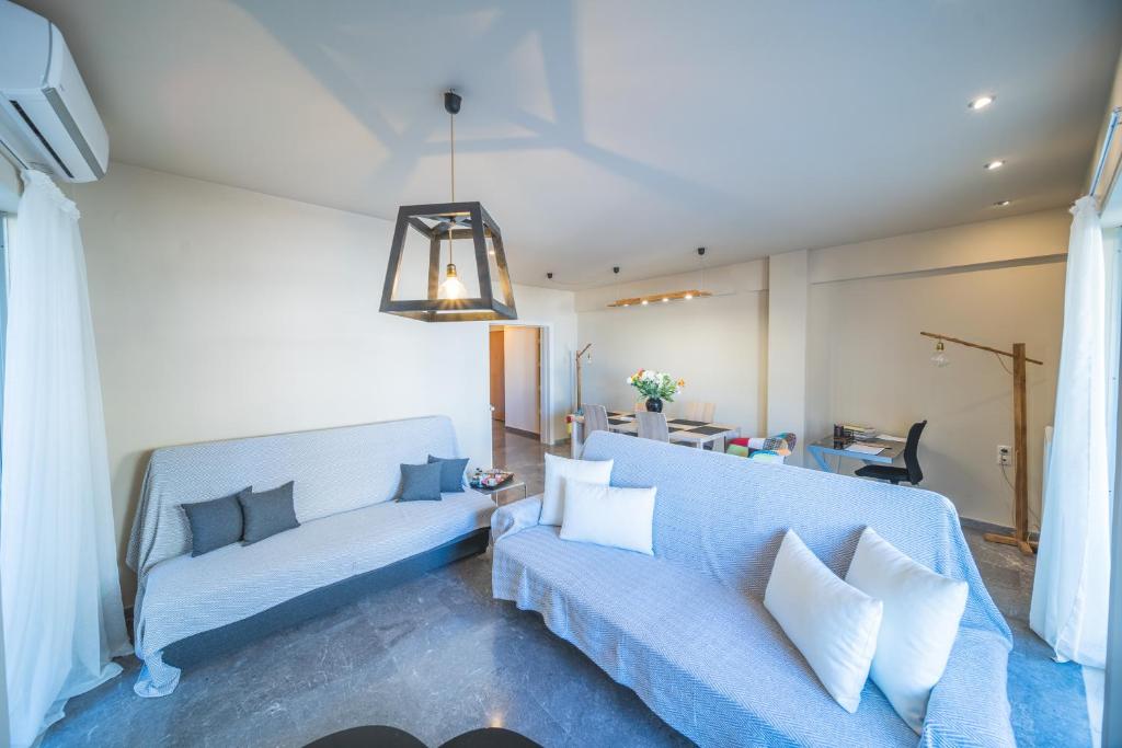 sala de estar con sofá azul y almohadas blancas en City Center Apartment Project, en Heraclión