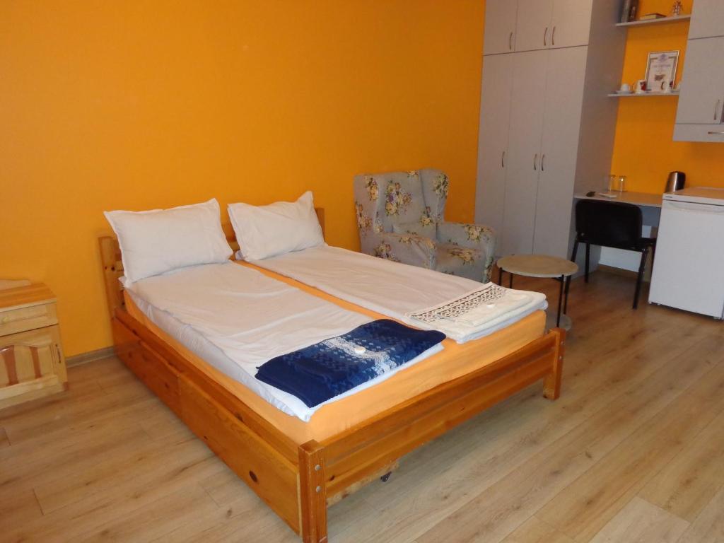 uma cama num quarto com uma parede amarela em Apartment Moni em Veliko Tarnovo