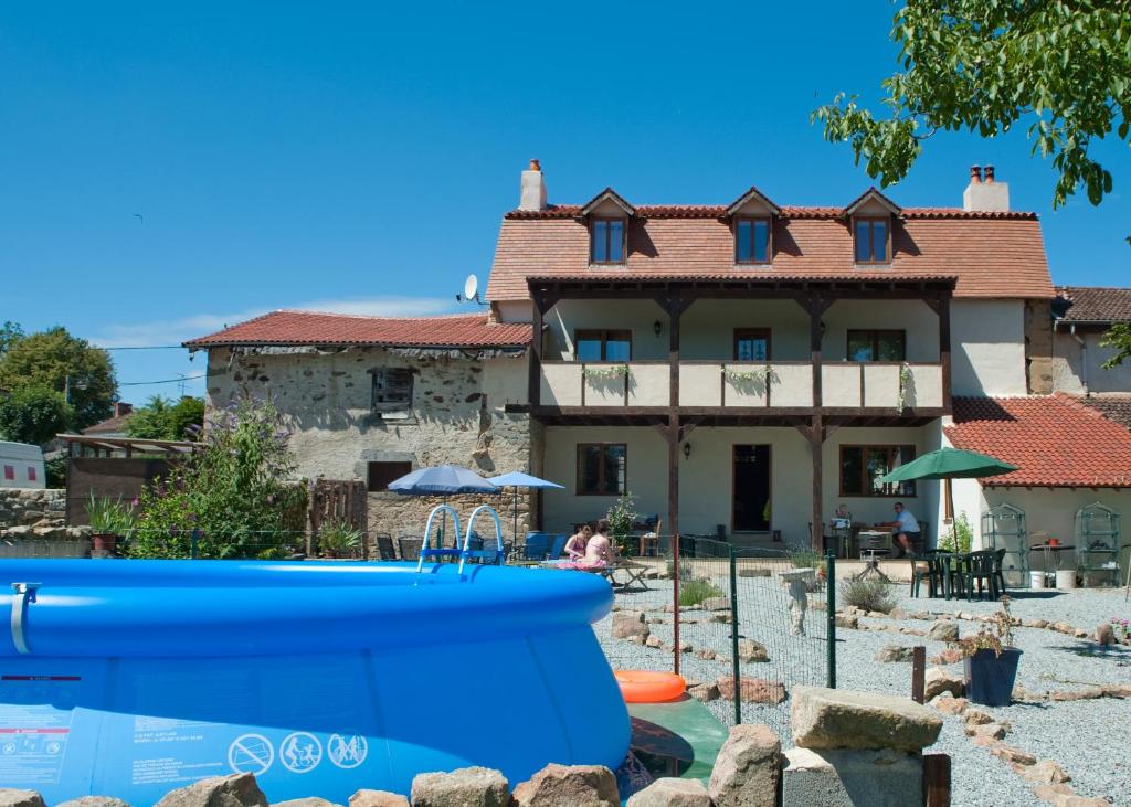 una casa con piscina frente a una casa en L'Ancien Presbytère Chambres D'hote ou Gite, en Le Dorat