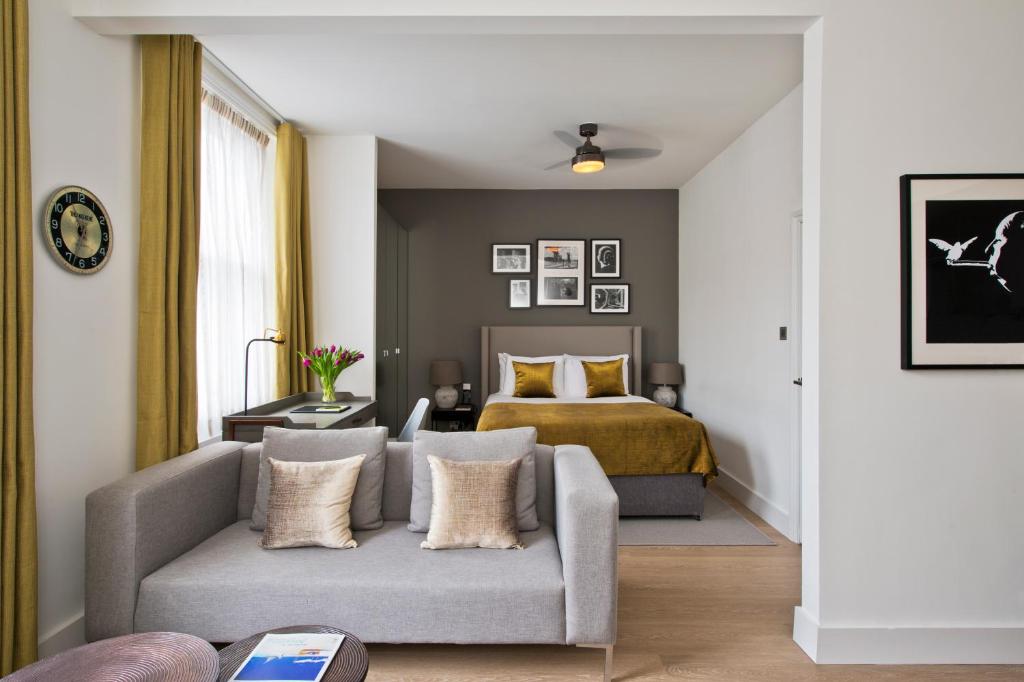 sala de estar con sofá y cama en Nevern Place by Supercity Aparthotels, en Londres