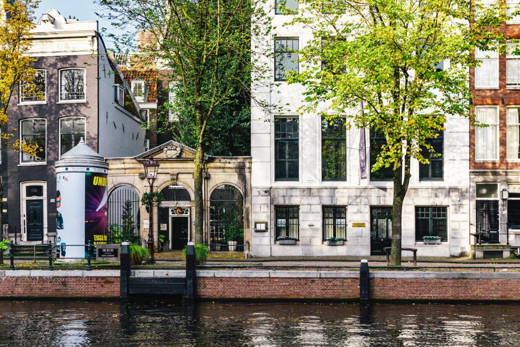a building on the side of a river with buildings at The Dylan Amsterdam - The Leading Hotels of the World in Amsterdam