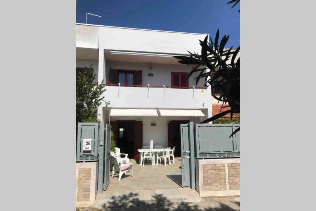 een wit huis met een patio en een tafel bij Rosato apARTment in Porto Cesareo in Porto Cesareo
