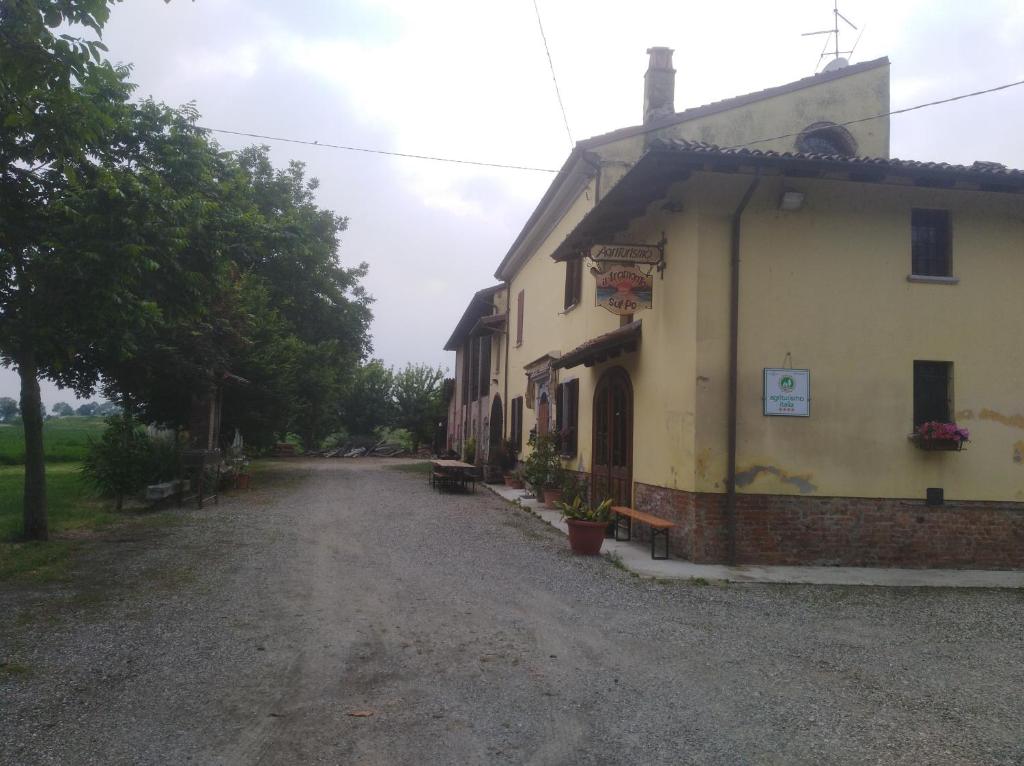 a building on a dirt road next to a house at IL TRAMONTO SUL PO in Calendasco