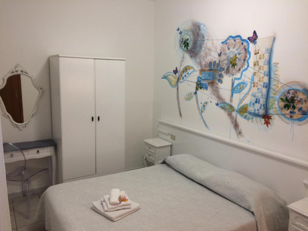 ノーリにあるHotel Gentileのベッドルーム1室(ベッド1台付)が備わります。壁には絵画が飾られています。