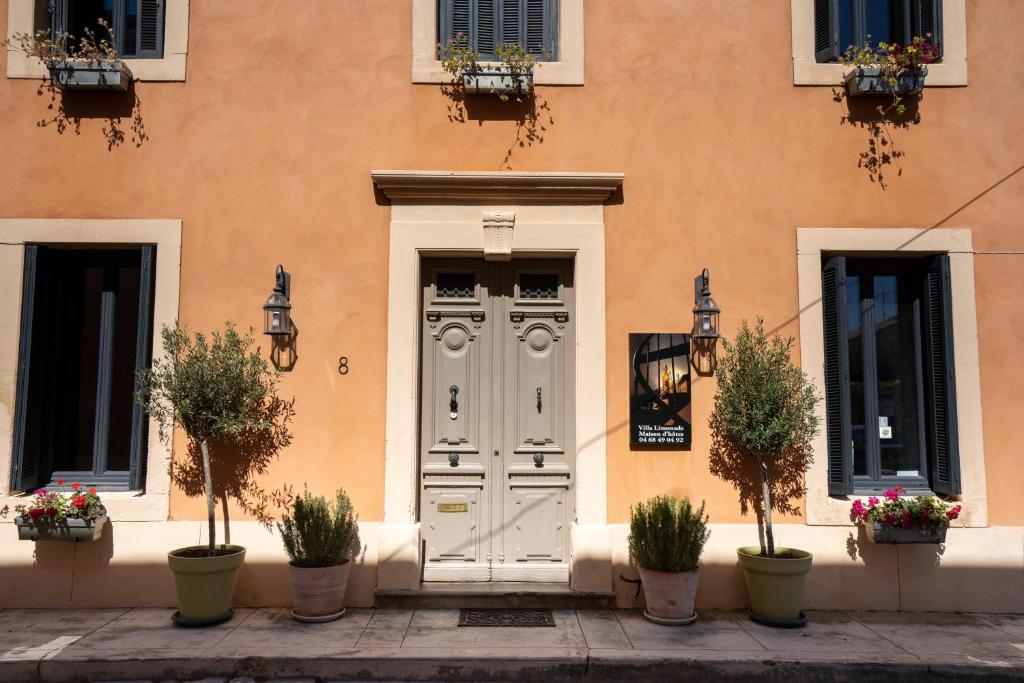 une porte d'un bâtiment avec des plantes en pot dans l'établissement Villa Limonade, maison d'hotes, à Olonzac