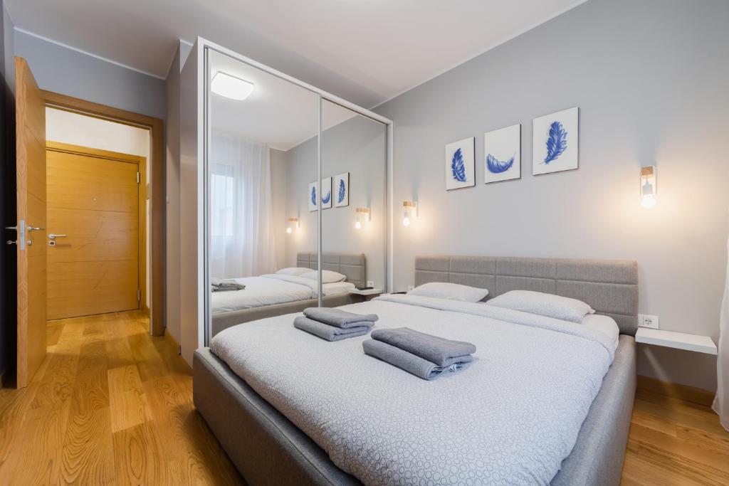 - une chambre avec 2 lits et un grand miroir dans l'établissement Modern Living in city centre - PRIVATE PARKING, à Novi Sad