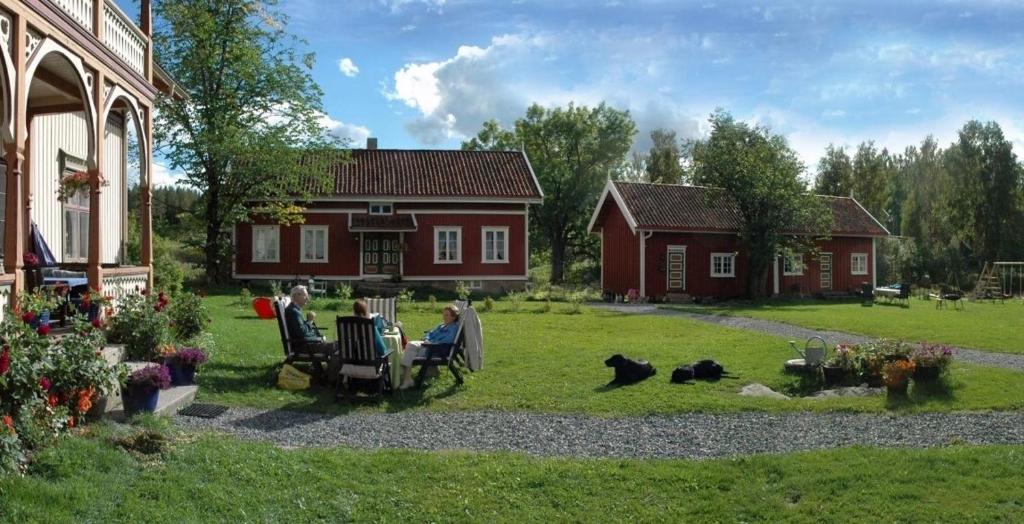 a group of people sitting in chairs in the yard of a house at Staurheim gård in Bø