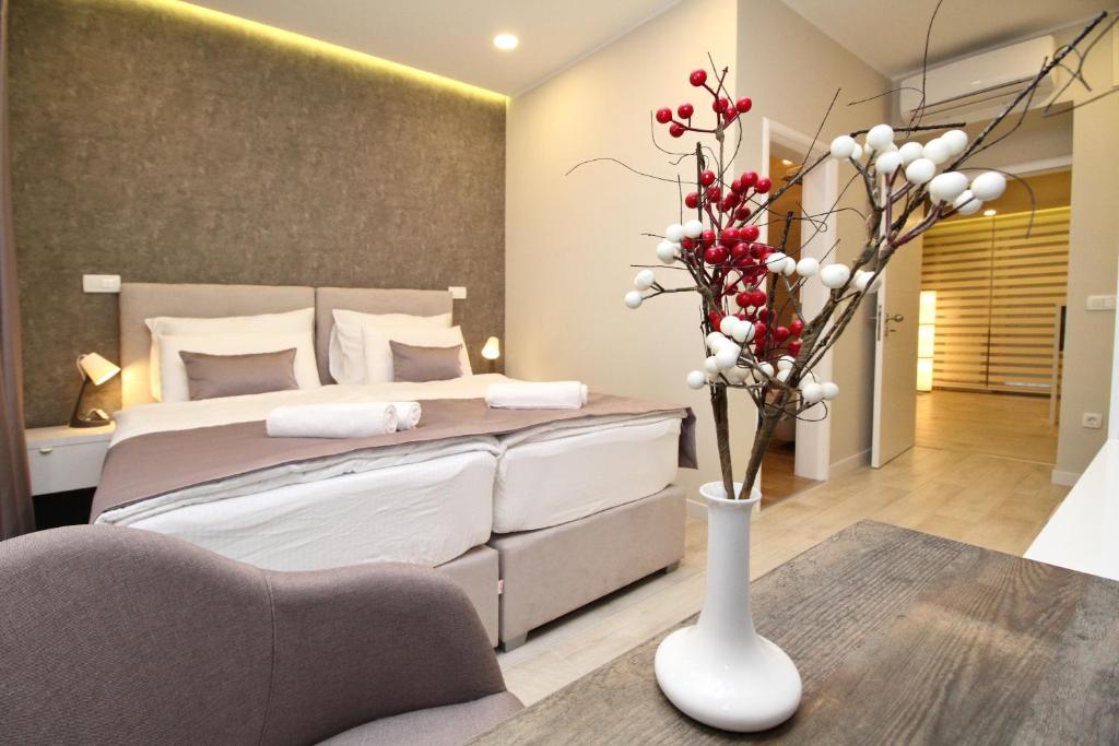 sypialnia z łóżkiem i wazonem z kwiatami w obiekcie PLATINUM ROOMS butique hotel w Sarajewie