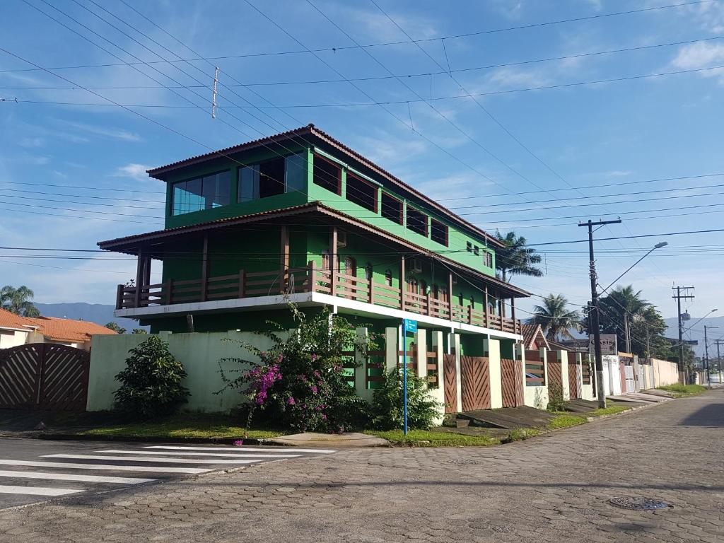 uma casa verde ao lado de uma rua em Oásis Pousada em Bertioga