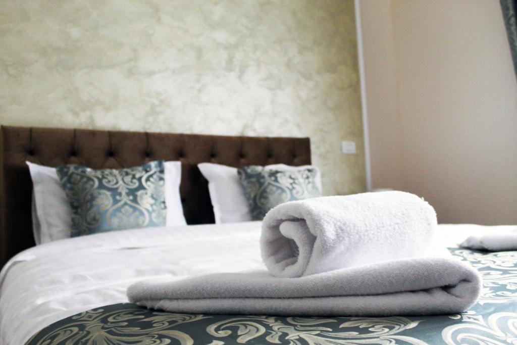 uma pilha de toalhas sentadas em cima de uma cama em Pensiunea Romeo Resort em Focşani