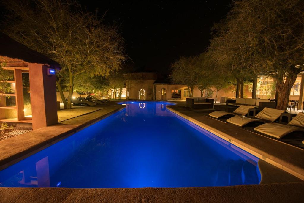 a swimming pool at night with blue lighting at Hotel La Aldea in San Pedro de Atacama