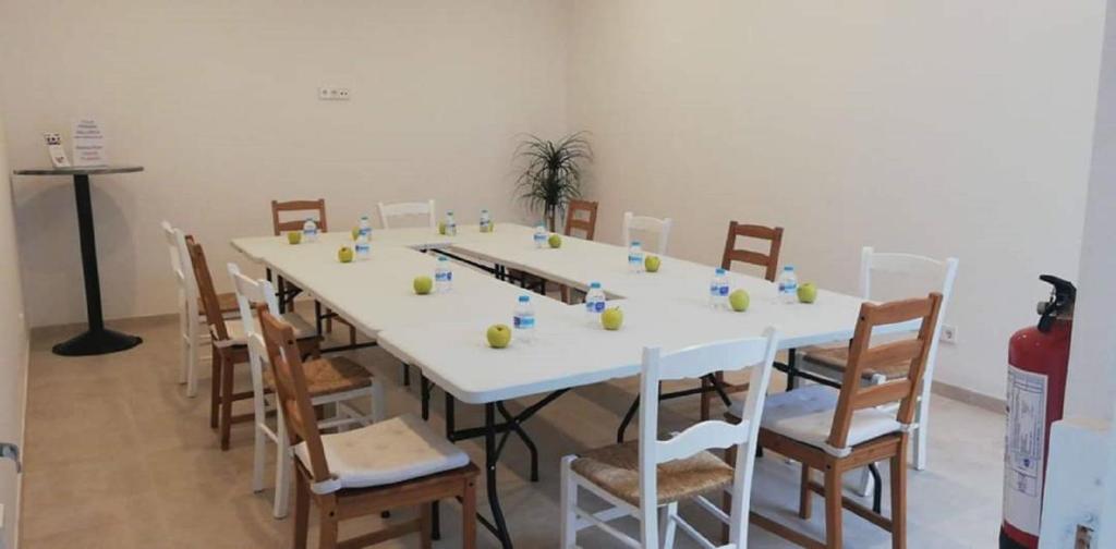 a long table with chairs and a white table at Apartamentos Villa Primera in Cala Figuera