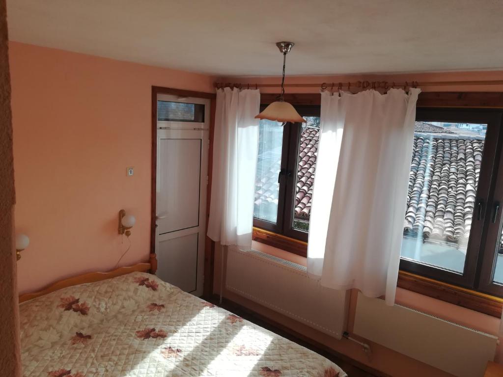 A bed or beds in a room at Guest House Terziiski