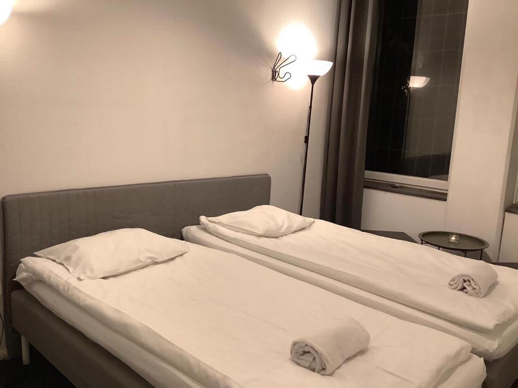 a hotel room with two beds and a lamp at Acco Hostel in Stockholm