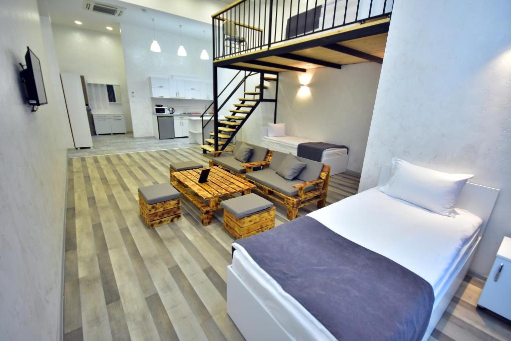 1 dormitorio con 1 cama, escalera y sala de estar. en LIBERECO Aparthotel, en Batumi
