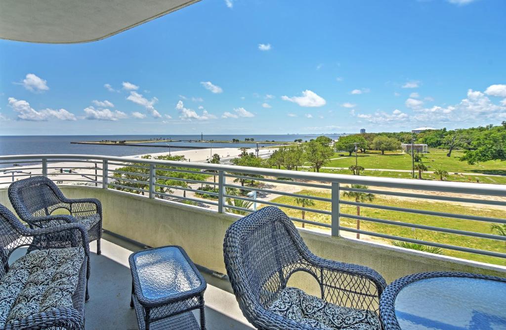 a balcony with chairs and a view of the beach at Beachside Biloxi Club Condo Balcony with Ocean View in Biloxi