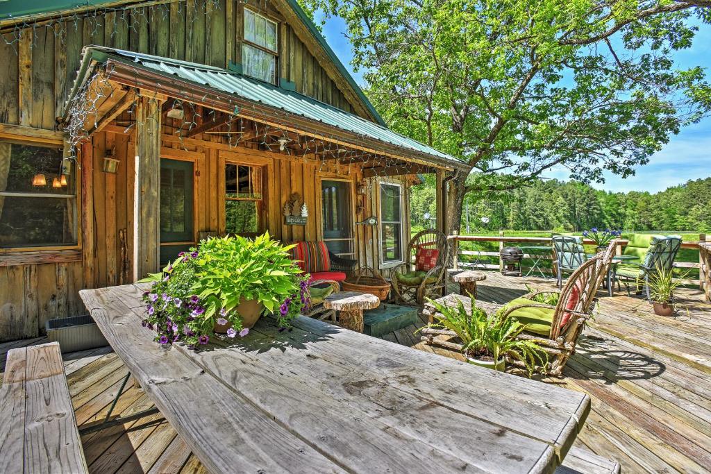 een houten hut met een houten tafel en stoelen bij Private Getaway on 270 Acres with Lake Swim and Canoe in Marble Hill