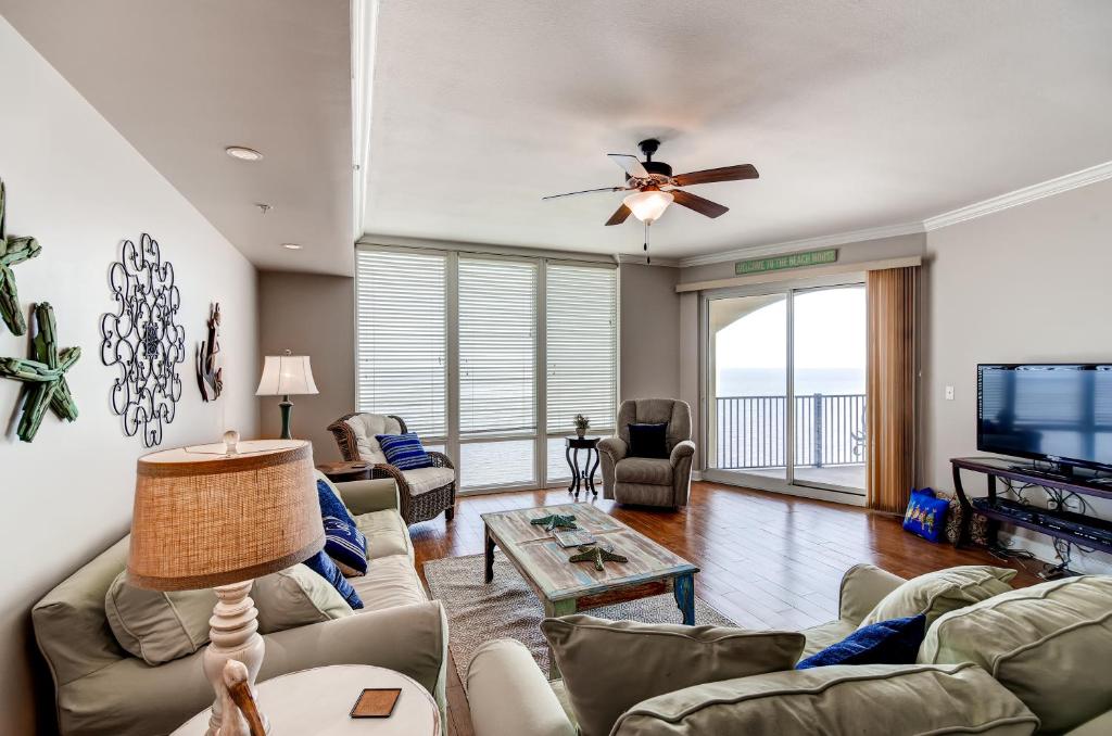 a living room with a couch and a tv at Sleek Gulfport Condo with Ocean Views and Pool Access! in Gulfport