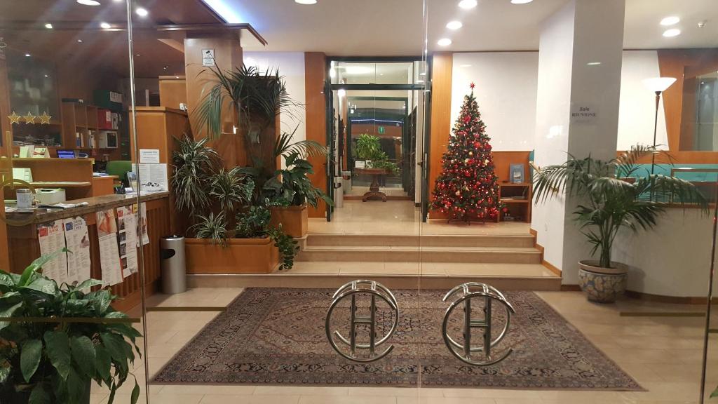 een kerstboom in het midden van een lobby bij Hotel Cristallo in Udine