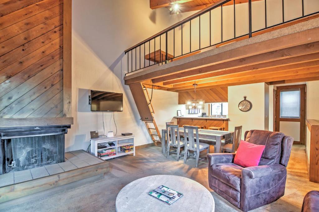 a living room with a fireplace and a table at Truckee Condo with Grill and Northstar Resort Shuttle in Truckee
